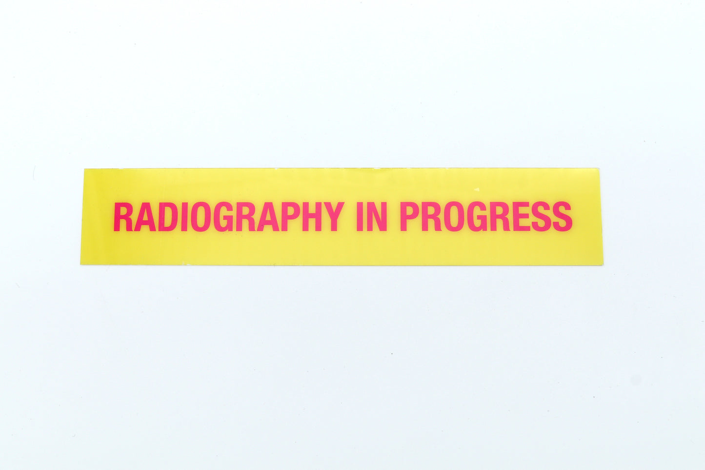 Yellow sign with 'Radiography in Progress' text on a white background