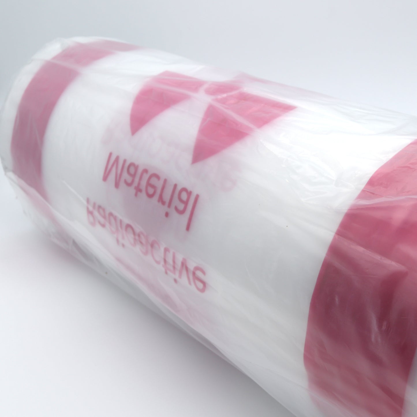 Roll of white paper with pink stripes and text on a white background
