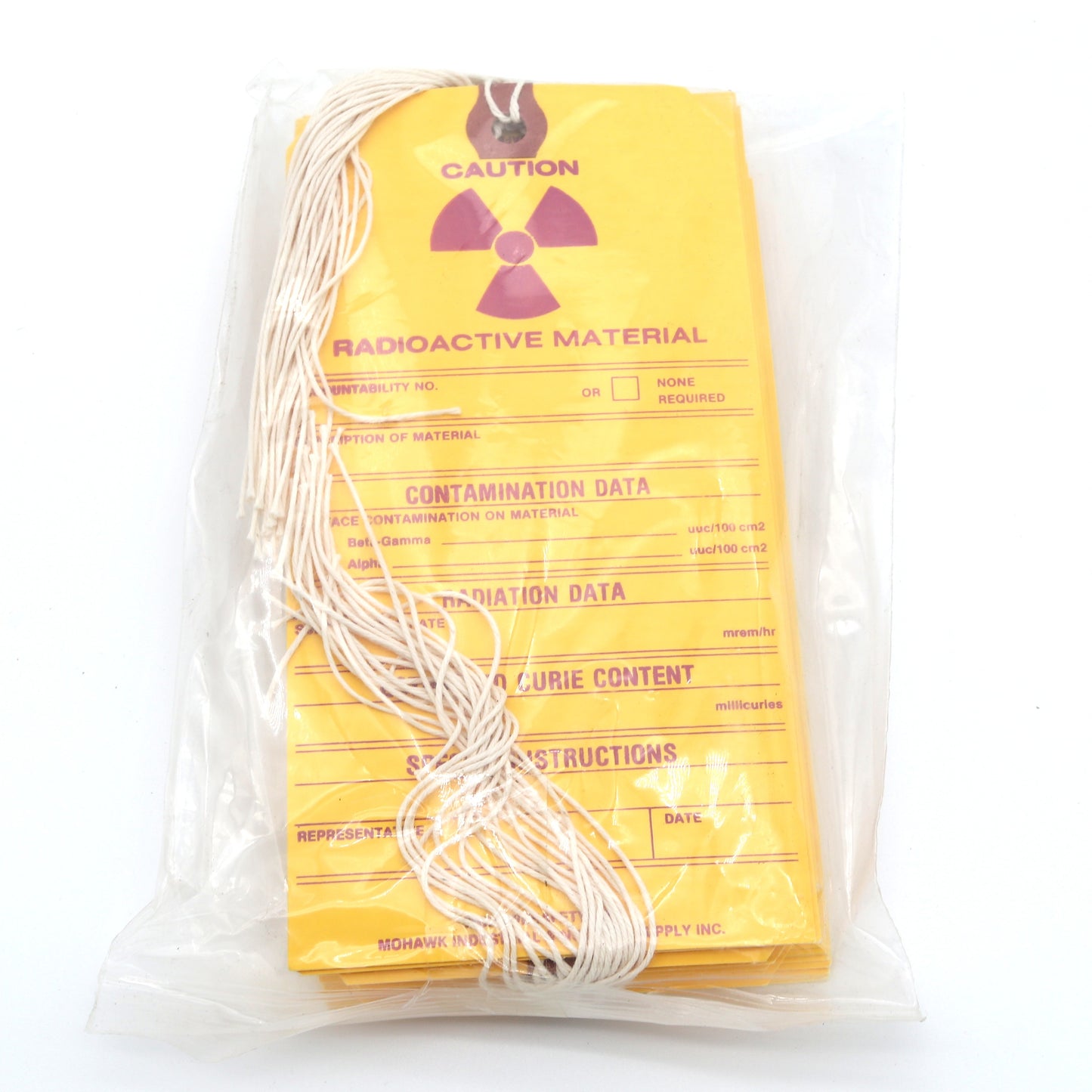 Packaged radioactive material with yellow warning label on a white background