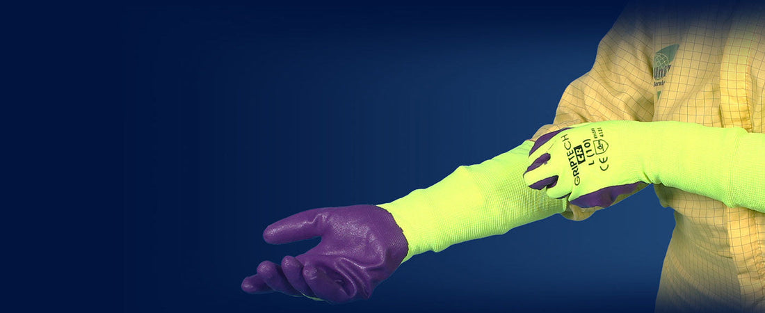 Person wearing a high-visibility UniTech GripTech glove with a warning label on a dark background