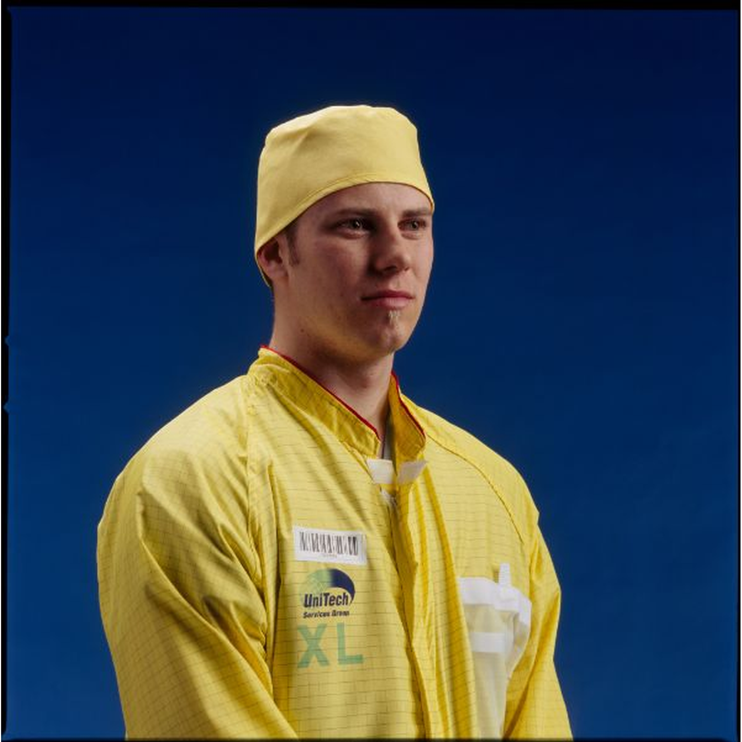 Person wearing a yellow uniform with a blue background