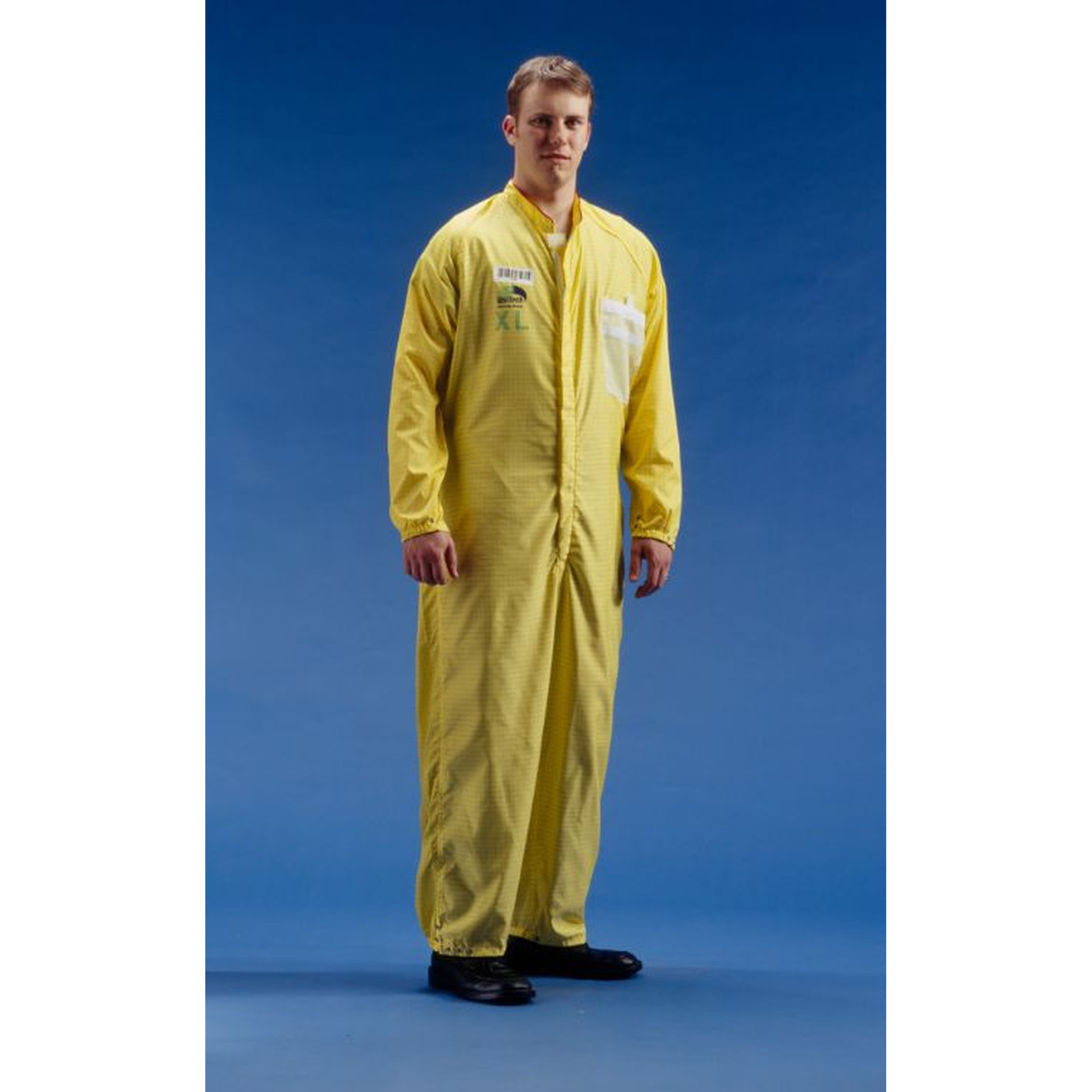 Person wearing a yellow coverall against a blue background