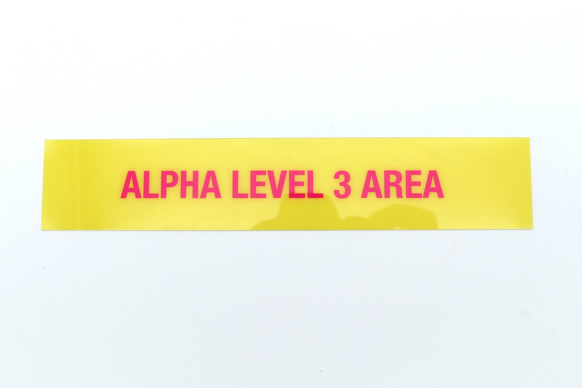 Yellow label with 'ALPHA LEVEL 3 AREA' text on a white background