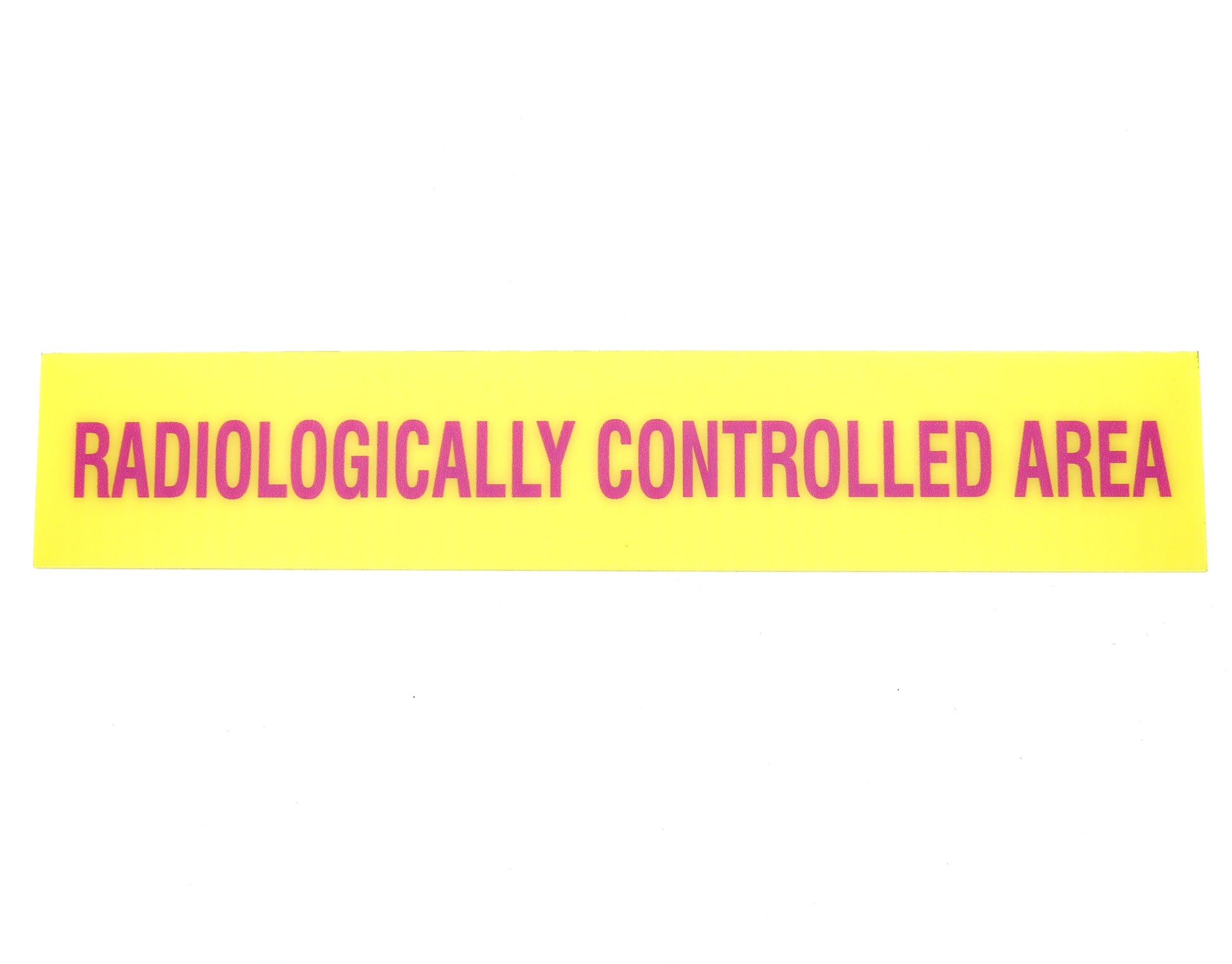 Yellow rectangular sign with pink text 'Radiologically Controlled Area' on a white background