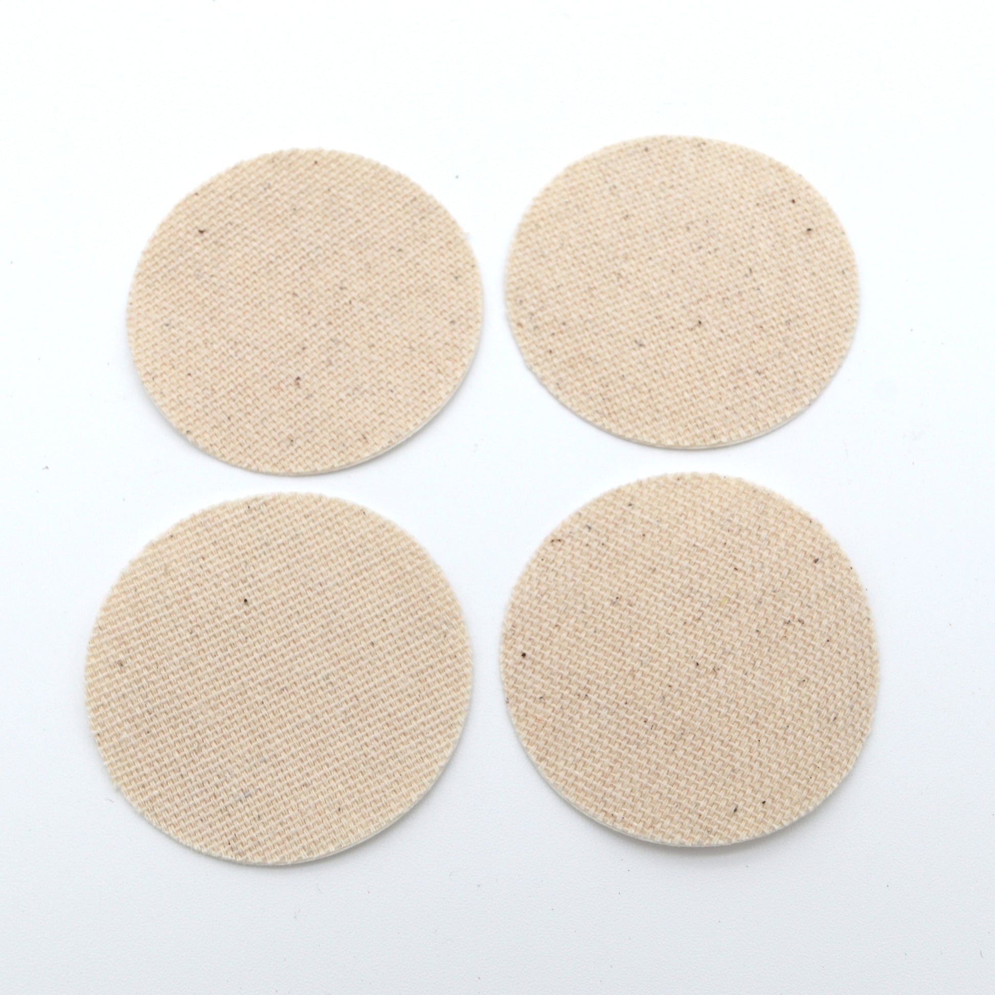 Four beige round smears on a white background