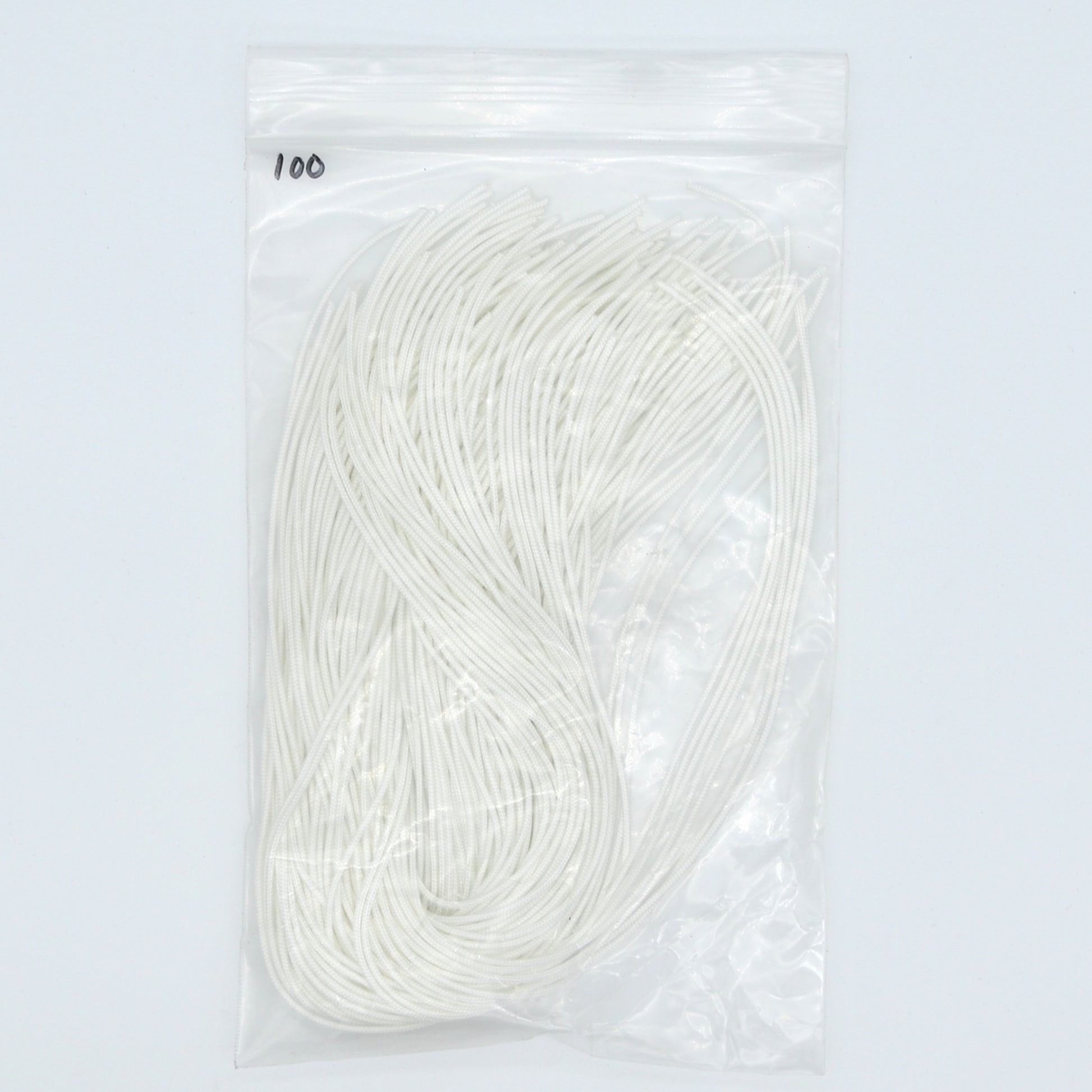 Packaged white elastic cords on a light gray background