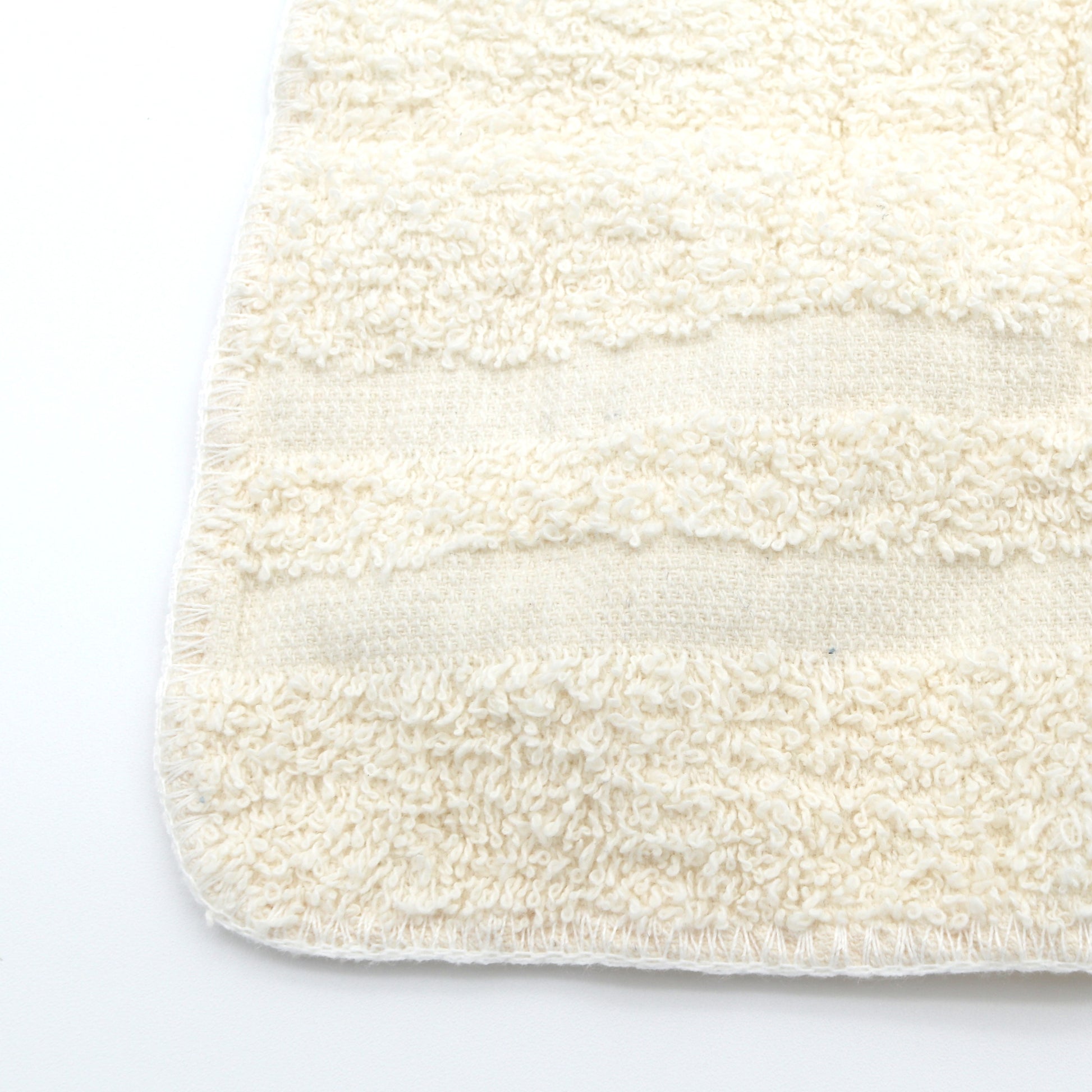 Close-up of a textured white washcloth on a white background