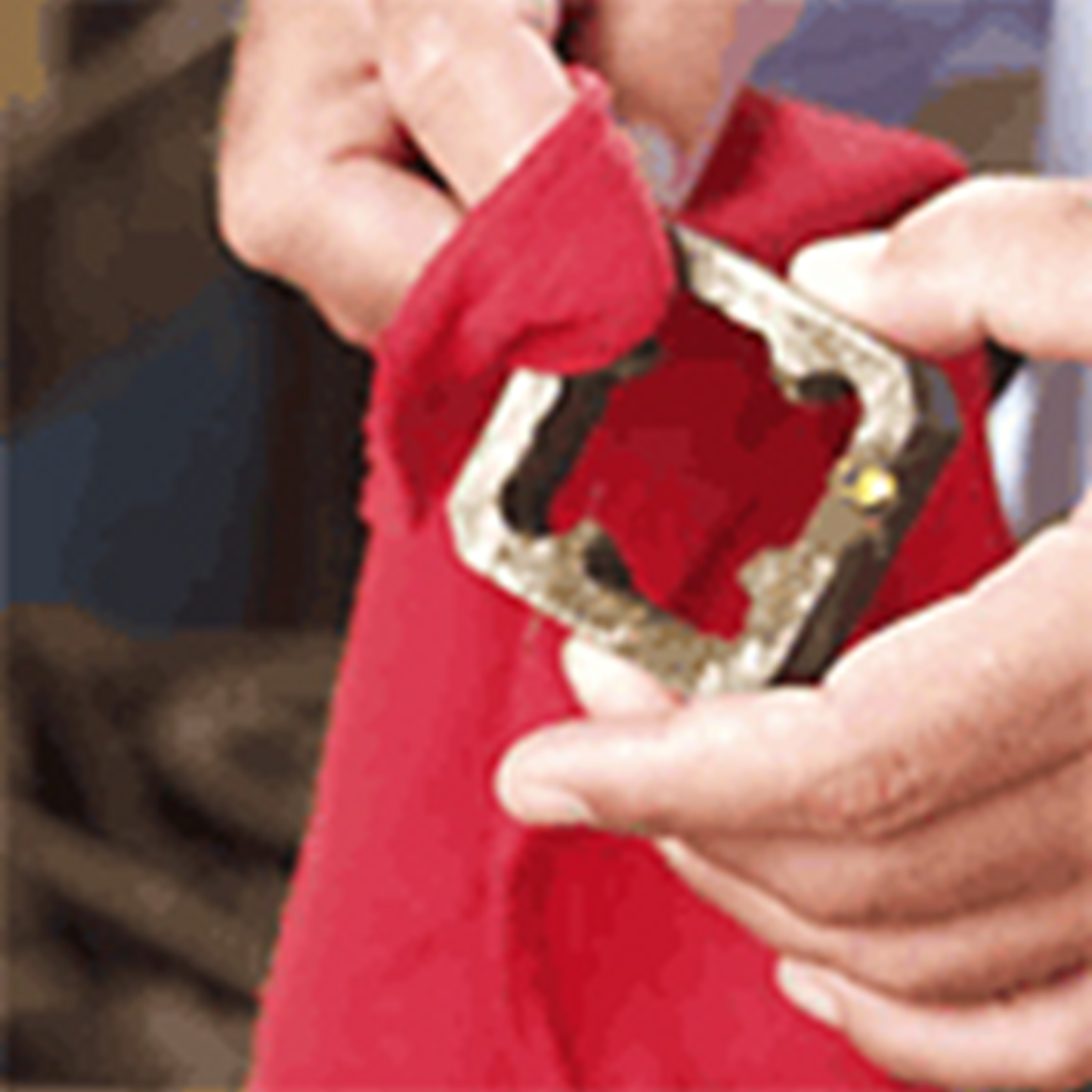 Close-up of a person using a red rag to clean a metal object