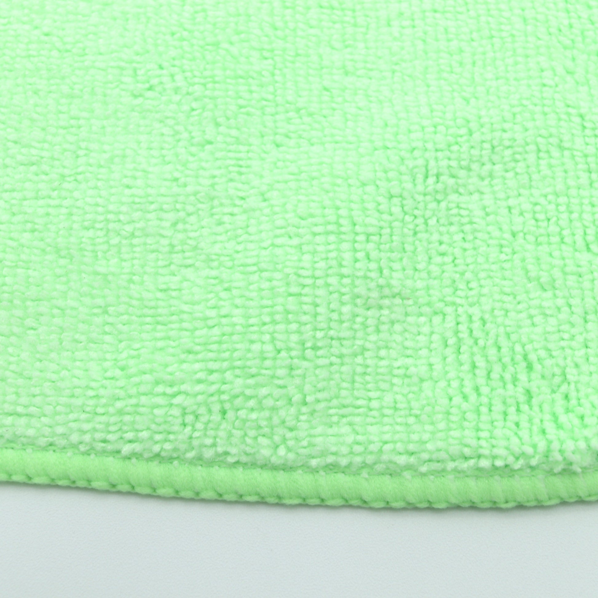 Close-up of a green microfiber cloth on a gray background