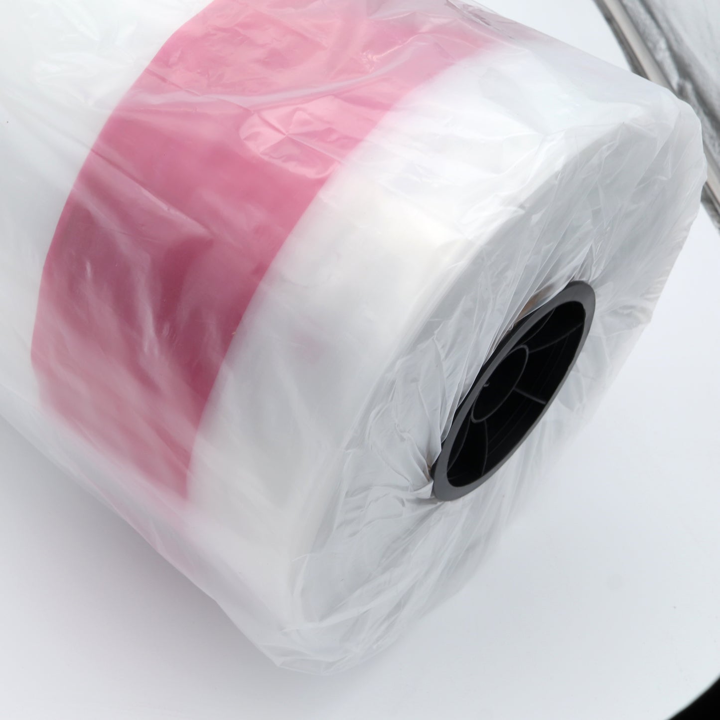 Roll of pink and white material on a white background
