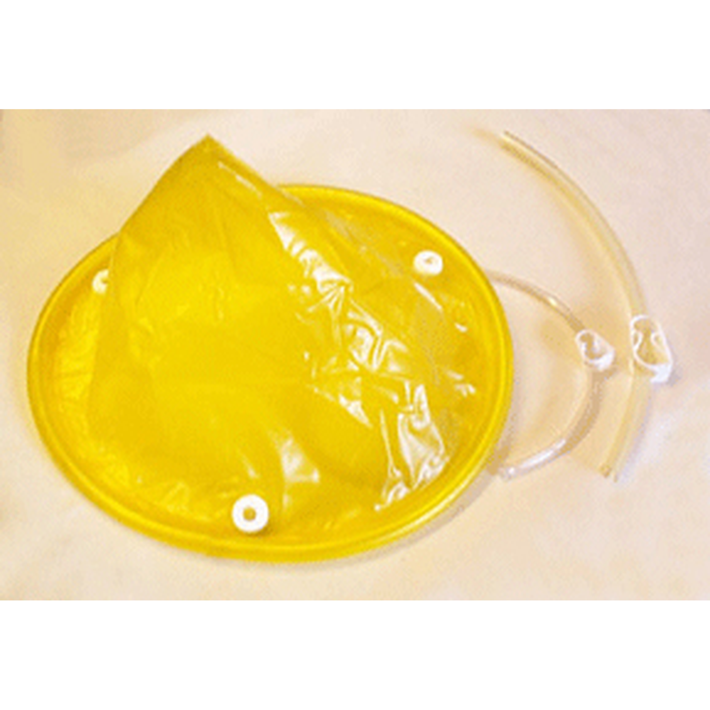 Yellow plastic cone-shaped object with a clear tube on a beige background