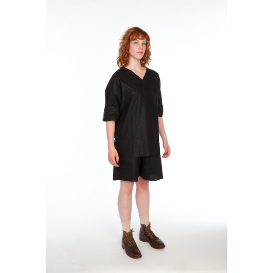 Person wearing black scrub shorts with a white background