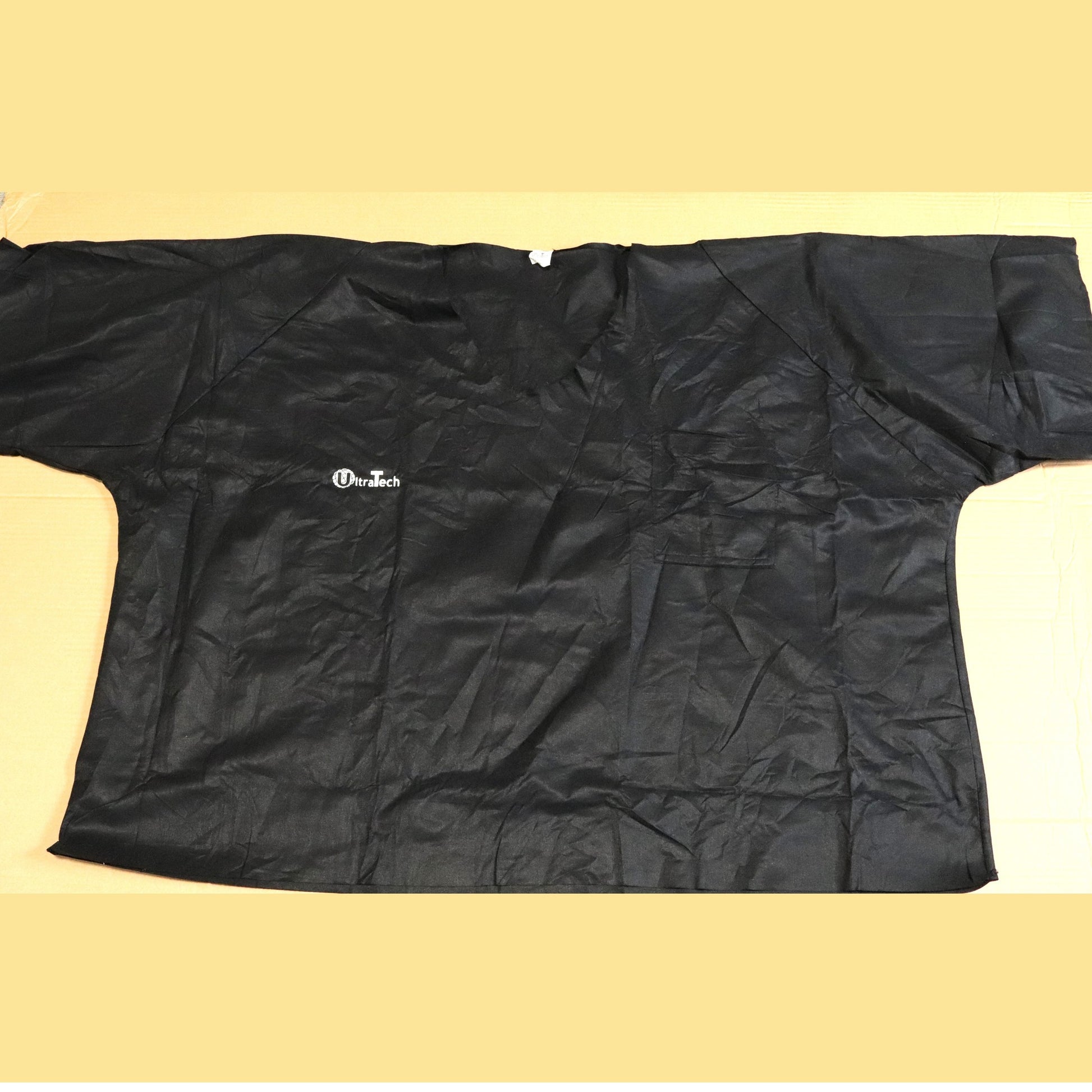 Black disposable scrub with a brand logo on a beige background
