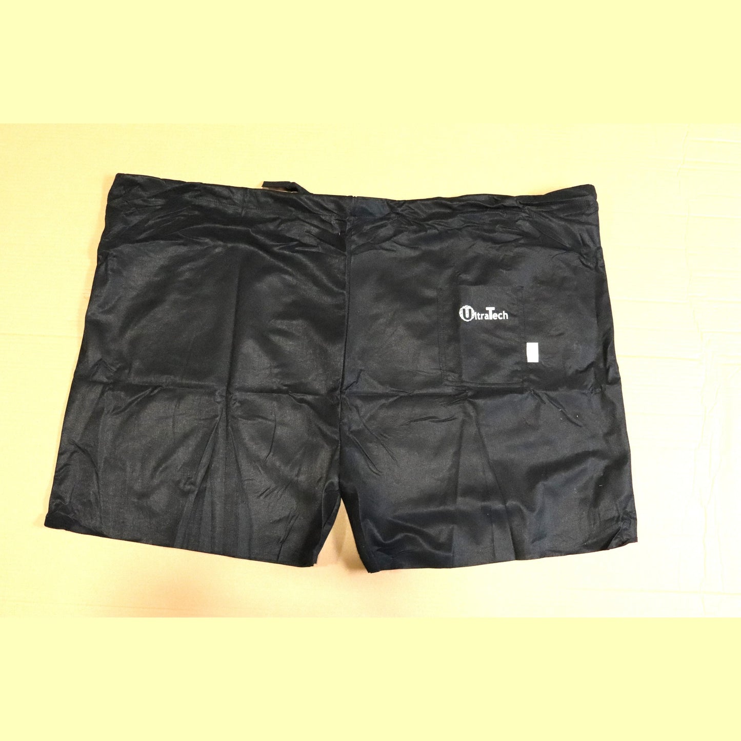 Black scrub shorts with a brand logo on a light yellow background