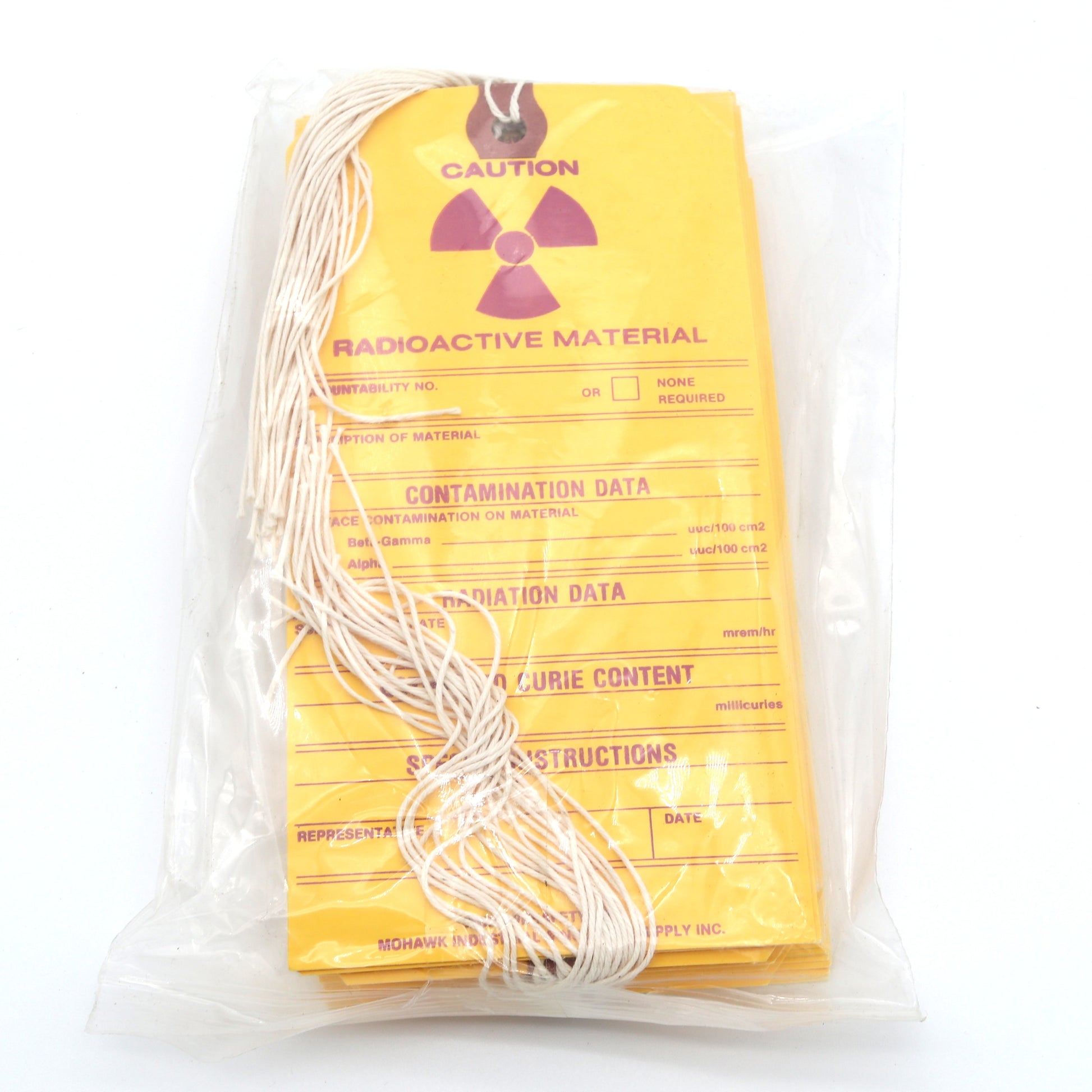 Packaged radioactive material with yellow warning label on a white background