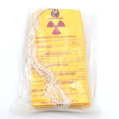 Packaged radioactive material with yellow warning label on a white background