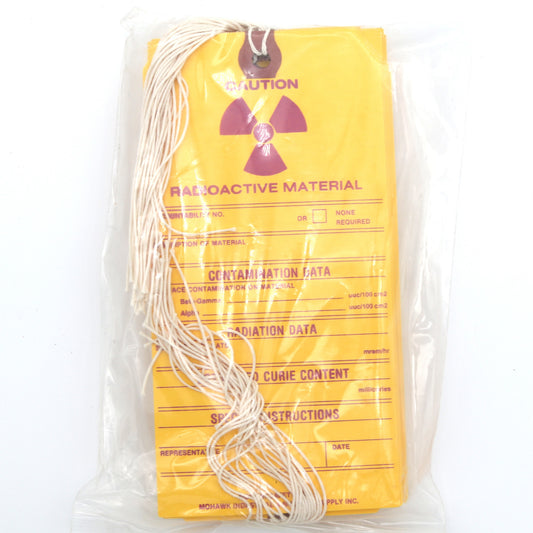 Packaged radioactive material with yellow warning label on a white background