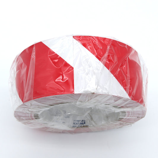 Red and white striped object wrapped in clear plastic on a white background