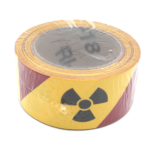 Roll of warning tape with a radiation symbol on a white background